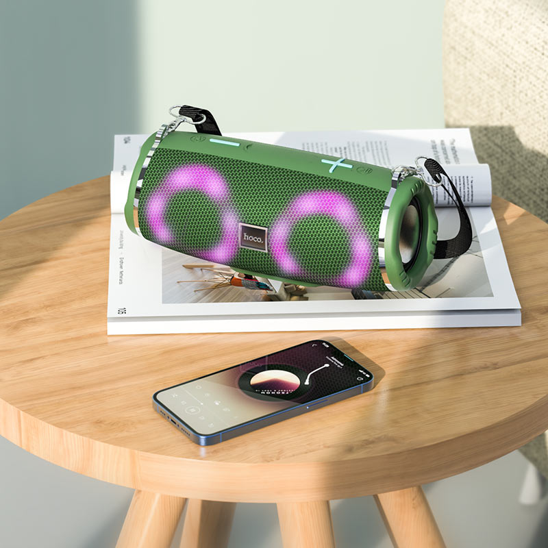 a green speaker sitting on top of a wooden table