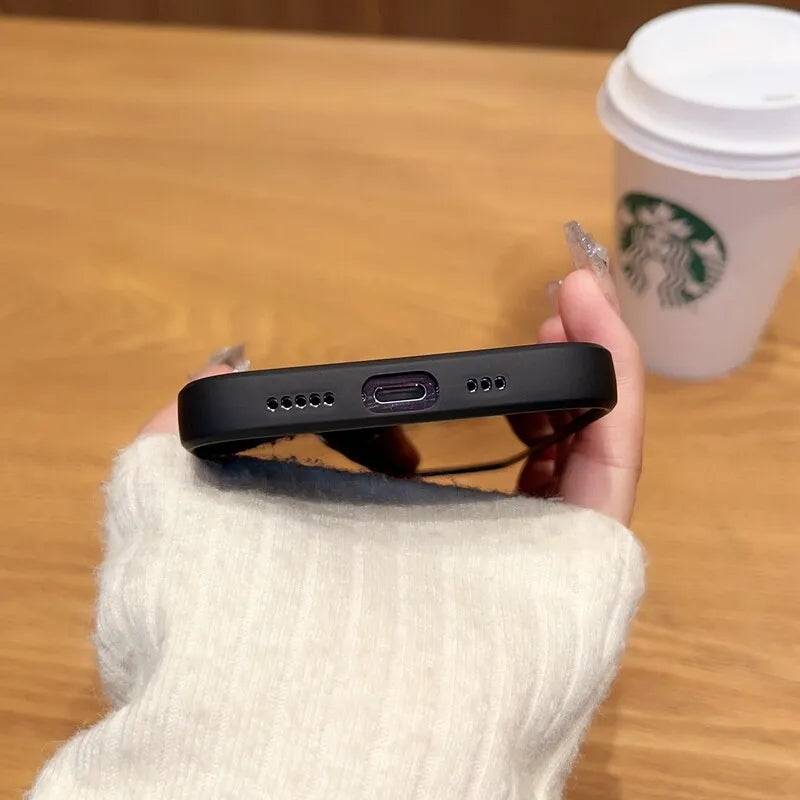 a person holding a cell phone next to a cup of coffee