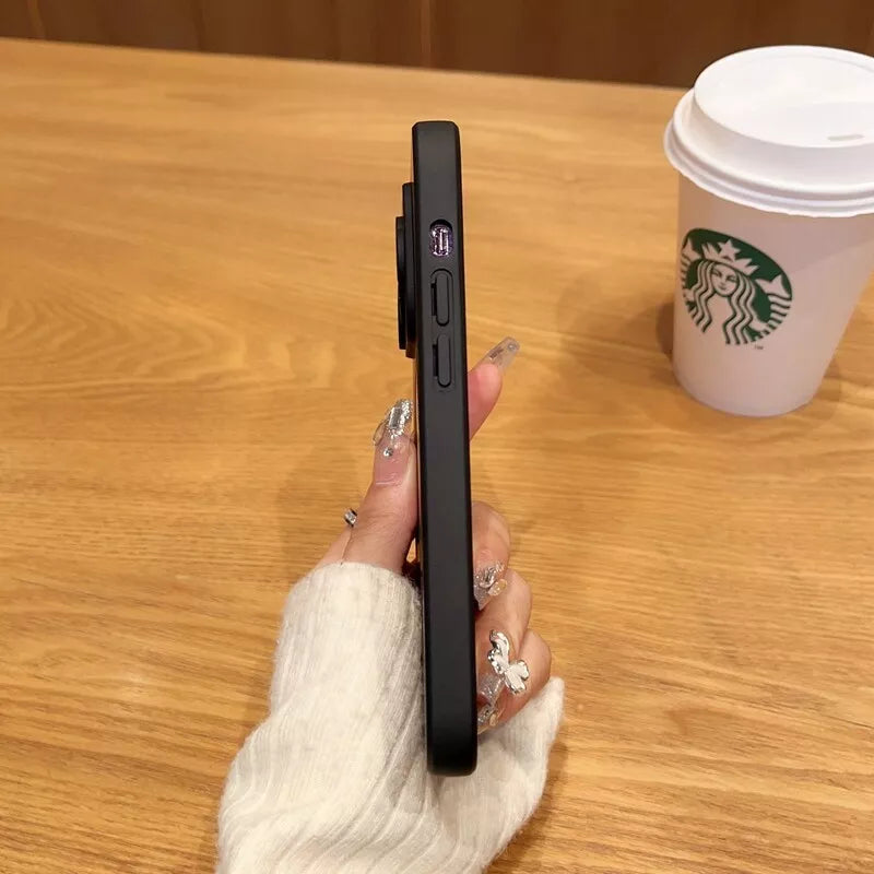 a woman holding a cell phone next to a cup of coffee